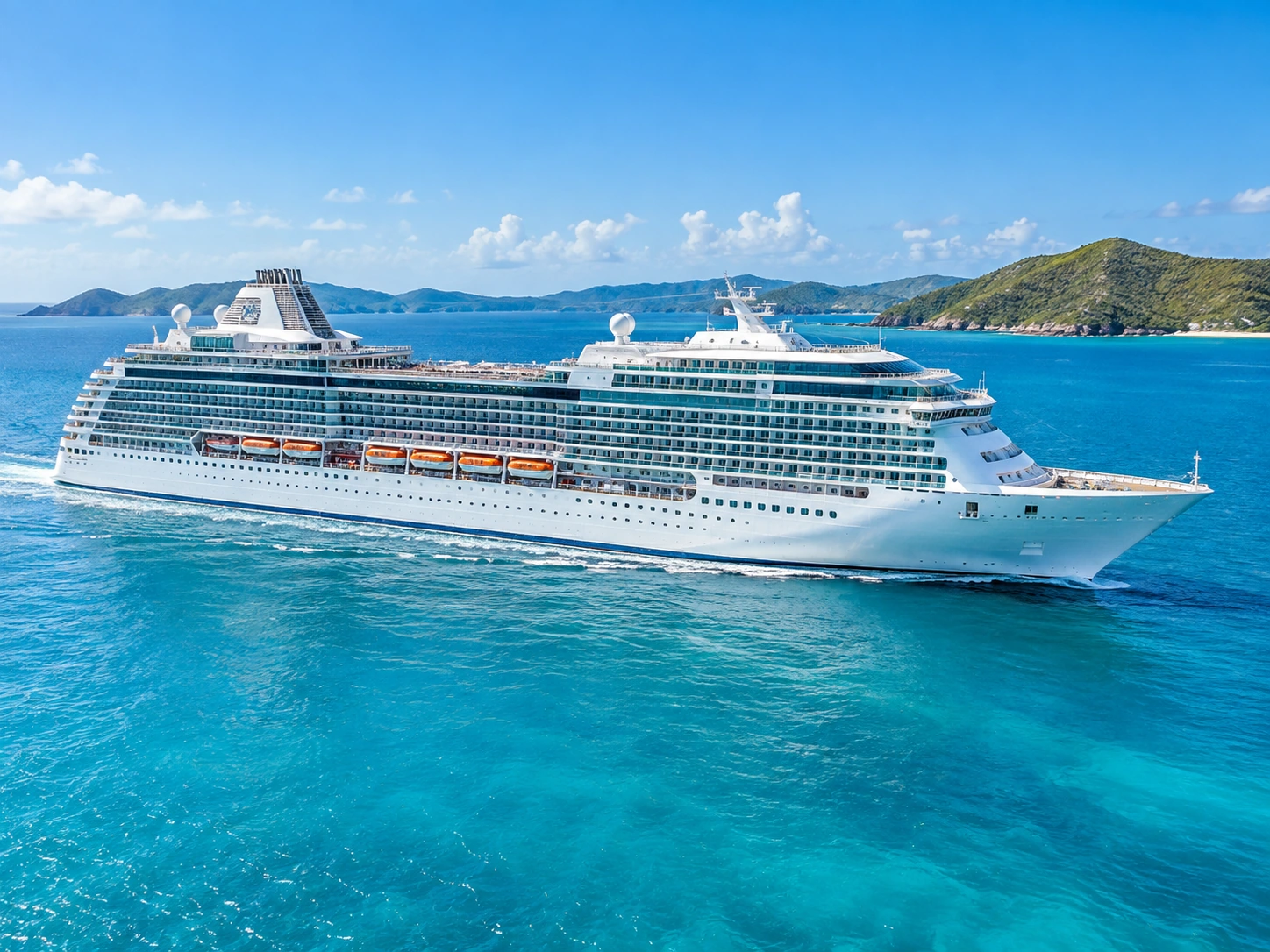 Large modern cruise ship sailing through bright blue Caribbean water